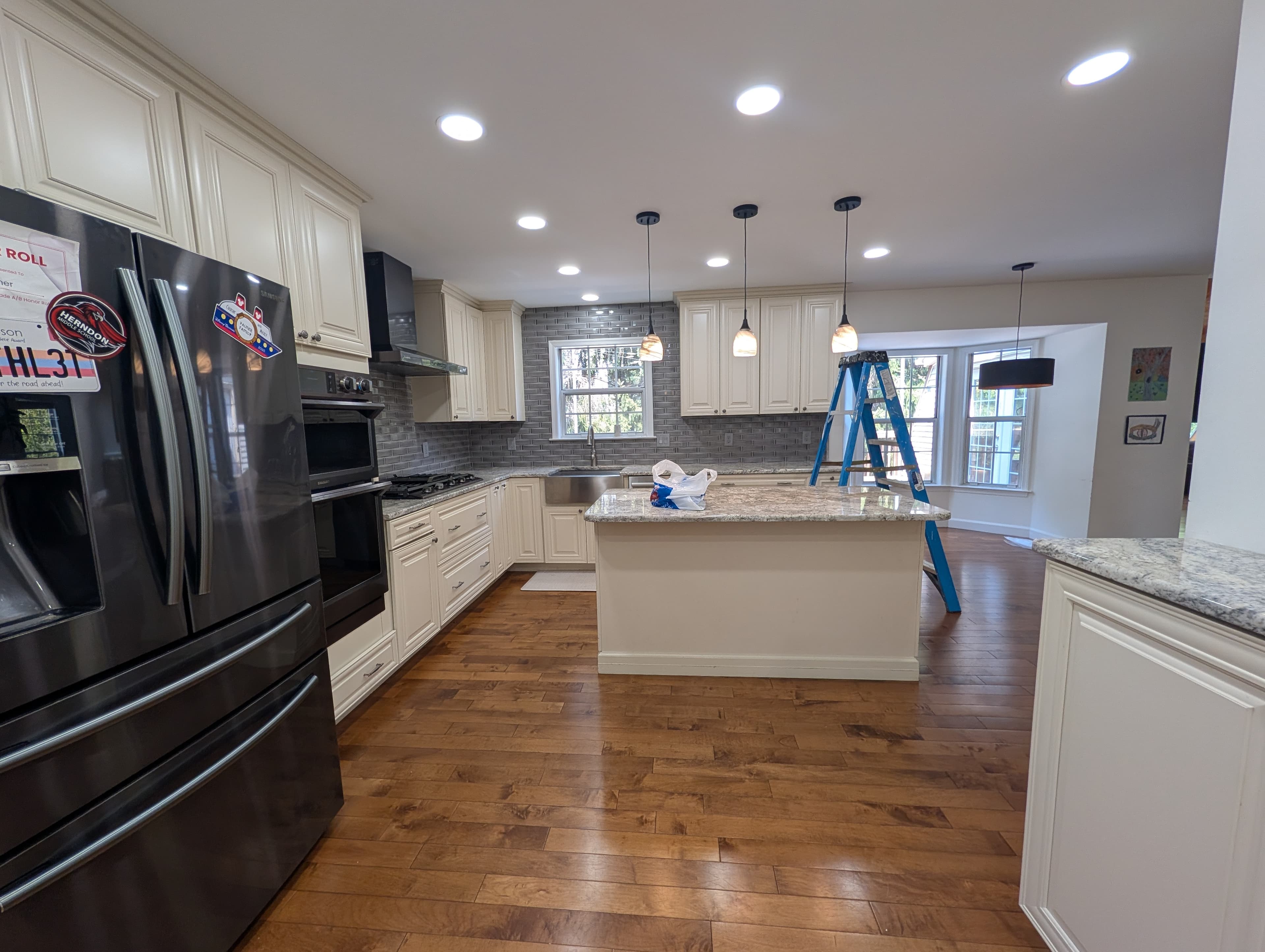 Original Herndon kitchen with cream raised-panel cabinets, granite countertops, and gray subway tile backsplash